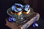 Eclairs with chocolate icing and candied blossoms