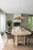 Langer Esstisch aus hellem Holz mit eleganten, gepolsterten Schalenstühlen
