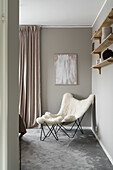 Sheepskin chair in bedroom in front of grey wall