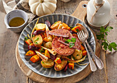 Warm potato and vegetable salad with ham steak