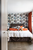 View of the bedroom with double bed and patterned wallpaper