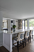 White kitchen counter and bar stools with floral upholstery