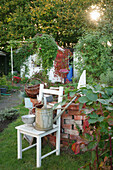 Dekoration mit altem Stuhl im Kleingarten mit Laube im Hintergrund