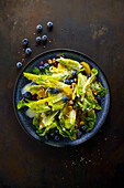Caesar salad with blueberries and hazelnuts