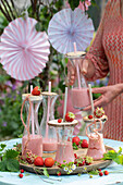 Strawberry shake in decorative bottles with wooden lids and straws