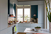 White fitted kitchen in open-plan living room