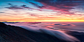 Long exposure of clouds and mist in the multicolored sky at dawn over Pico de la Zarza, Fuerteventura, Canary Islands, Spain, Atlantic, Europe