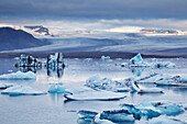 Eisschollen in der Lagune von Jokulsarlon, Blick auf die Vatnajokull-Eiskappe, Vatnajokull-Nationalpark, Südküste Islands, Polargebiete