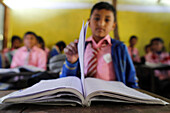 Grundschule, Junge mit Buch, Konzept von Bildung und Schulleben, Lapilang, Dolakha, Nepal, Asien