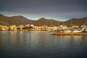 Blick auf den Sonnenaufgang, der sich in den Hotels und Bars in Port de Pollenca spiegelt, Port de Pollenca, Mallorca, Balearen, Spanien, Mittelmeer, Europa