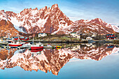 Fishing boats and snowcapped mountains mirrored in the fjord at sunrise, Ballstad, Vestvagoy, Lofoten Islands, Norway, Scandinavia, Europe