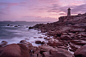 Pink sunset long exposure at Ploumanach lighthouse with the pink granite coast, Cotes d'Armor, Brittany, France, Europe