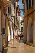 Blick auf pastellfarbene Arkaden in einer engen Straße, Ciutadella, Menorca, Balearen, Spanien, Mittelmeer, Europa