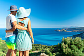 Man and woman in love embracing looking at the crystal sea, Myrtos beach, Kefalonia, Ionian Islands, Greek Islands, Greece, Europe