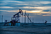 Ölplattformen bei Sonnenuntergang, Novy Uzen, Mangystau, Kasachstan, Zentralasien, Asien
