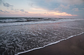 Wellen des Atlantiks bei Sonnenuntergang, Holden Beach, North Carolina, Vereinigte Staaten von Amerika, Nordamerika