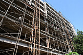Construction workers on a prime location scaffolded building site in the business area of Memnagar, Ahmedabad, Gujarat, India, Asia