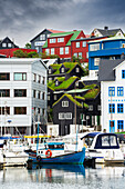 Alte Grasdachhäuser zwischen neuen Gebäuden und Booten im Hafen von Torshavn, Streymoy Insel, Färöer Inseln, Dänemark, Europa