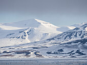 Schneebedeckte Berge und kahle Felsen an der Küste von Spitzbergen, Storfjorden, Svalbard, Norwegen, Europa