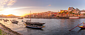 View of Douro River and Rabelo boats aligned with colourful buildings at sunset, Porto, Norte, Portugal, Europe