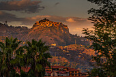 Blick auf die auf einem Hügel gelegene Stadt Castelmola bei Sonnenuntergang von den Giardini Naxos, Taormina, Sizilien, Italien, Mittelmeer, Europa