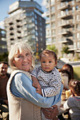 Lächelnde Großmutter mit Baby im Arm