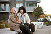 Portrait of young female friends sitting outdoors