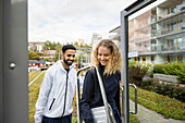 Junge Techniker betreten ein Gebäude mit einer Leiter