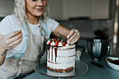 Frau in der Küche beim Verzieren von Kuchen