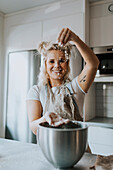 Happy woman baking in kitchen