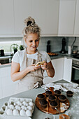Frau beim Fotografieren von frisch gebackenen Cupcakes