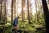 Frau beim Pilzesammeln im Wald