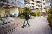 Junge fährt in einem Wohngebiet Skateboard