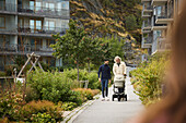 Men with baby stroller walking in residential area