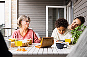 Family sitting at table outdoors