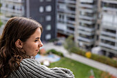 Smiling teenage girl looking at view from balcony