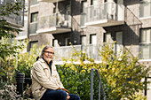 Porträt eines älteren Mannes, der in einem Wohngebiet sitzt