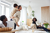 Mother giving son piggyback ride at home