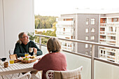 Älteres Paar frühstückt auf dem Balkon