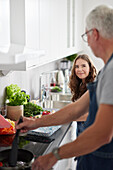 Father and daughter preparing food in kitchen