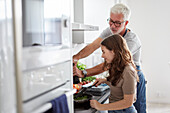 Vater und Tochter bereiten Essen in der Küche zu