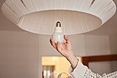 Woman's hands changing light bulb
