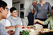 Family sitting at table and preparing meal