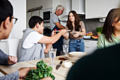 Familie sitzt am Tisch und bereitet das Essen vor