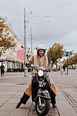 Lächelnde Frau auf Motorroller