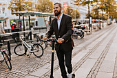 Smiling businessman using scooter