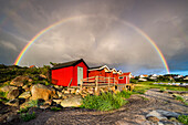 Regenbogen über Holzhäusern