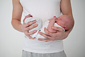 Mans hands holding newborn baby