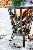 Firewood burning in metal basket