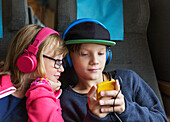 Brother and sister using with headphones